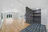 Entry foyer featuring hexagonal floor tiling, leading to a spacious living area with wood-finish flooring and a hallway to the rest of the main floor.