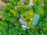 Expansive property featuring a private tennis court, a sparkling swimming pool, a substantial residence with a shingle roof, lush landscaping with mat