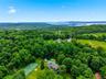Expansive property featuring a tennis court, swimming pool, and wooded surroundings