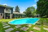 Inviting in-ground swimming pool with a stone coping and a white pergola