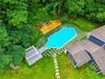 In-ground swimming pool with geometric paving, surrounded by lush green lawn