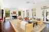 The formal living room with french doors overlooking the ocean and spilling onto a covered and screened terrace overlooking the pool