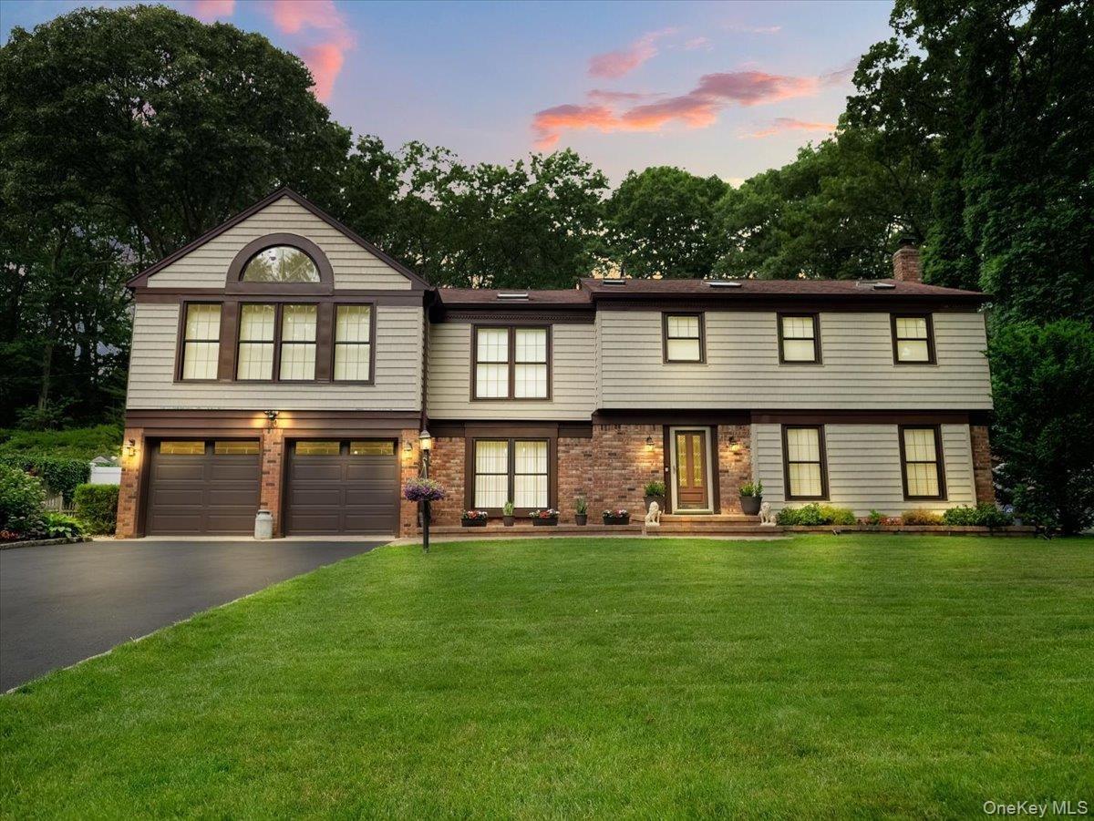 Two-story residence featuring light gray siding, brick accents, and a brown trim