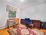 Room featuring hardwood flooring, white baseboards, and a window with blinds