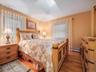 Bedroom featuring hardwood flooring, a skylight, and two windows with blinds