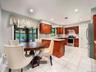 Well-appointed kitchen featuring wood cabinetry, stainless steel appliances, and a tiled backsplash
