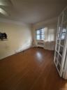 Unfurnished room with wood finished floors, radiator, and crown molding
