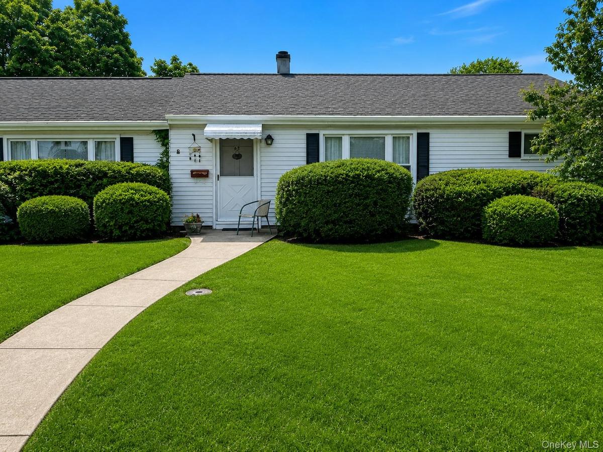 Single-story residence featuring white siding, a dark shingle roof, and black window shutters