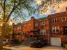 Brick facade residence featuring multiple windows, a front porch with an awning, and a private driveway