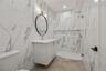 Bathroom with a marble finish shower and vanity