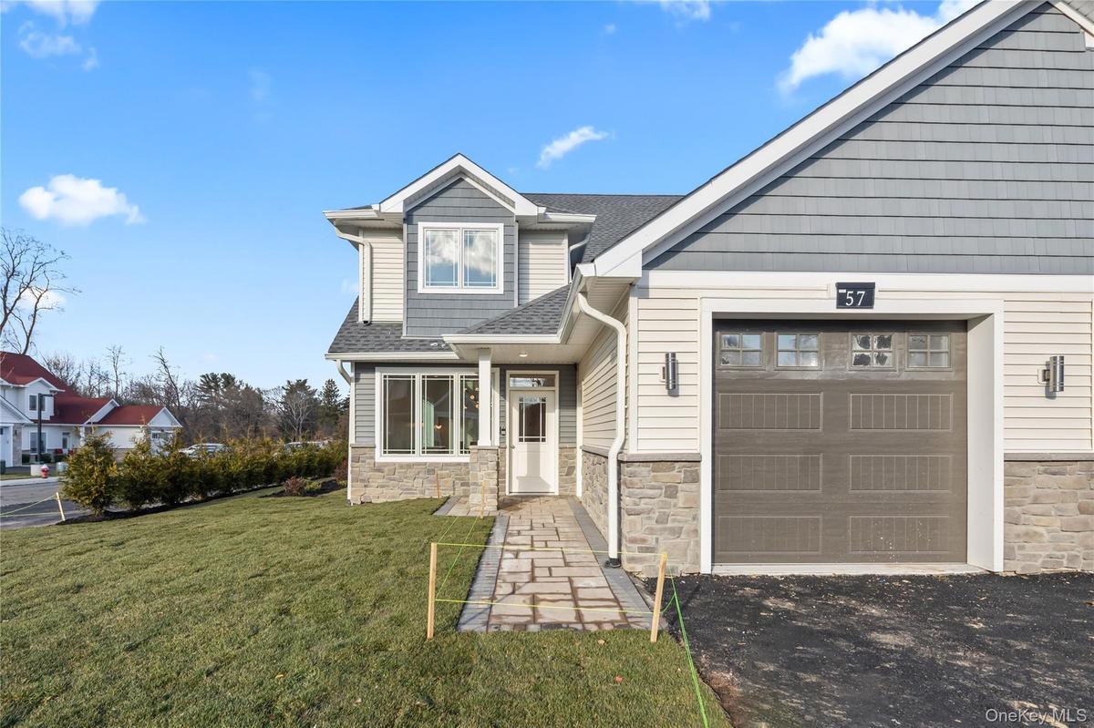Craftsman house with stone siding, a front yard, and roof with shingles