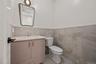 Bathroom with vanity, tile walls, light tile patterned floors, and a wainscoted wall