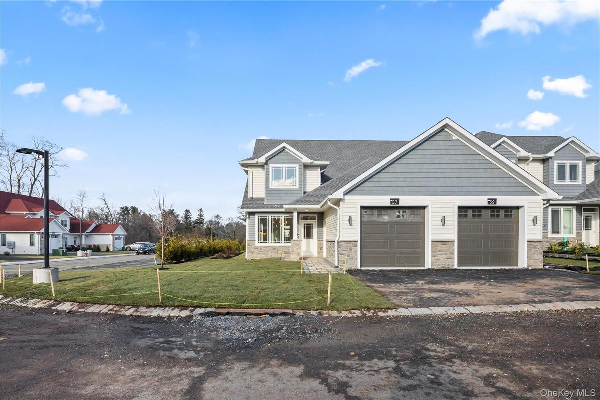 Craftsman inspired home featuring stone siding, asphalt driveway, a front yard, and a garage