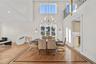 Dining room with recessed lighting, light wood-type flooring, a chandelier, and a high ceiling