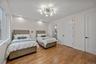 Bedroom with light wood-style flooring, recessed lighting, ensuite bathroom, and a chandelier
