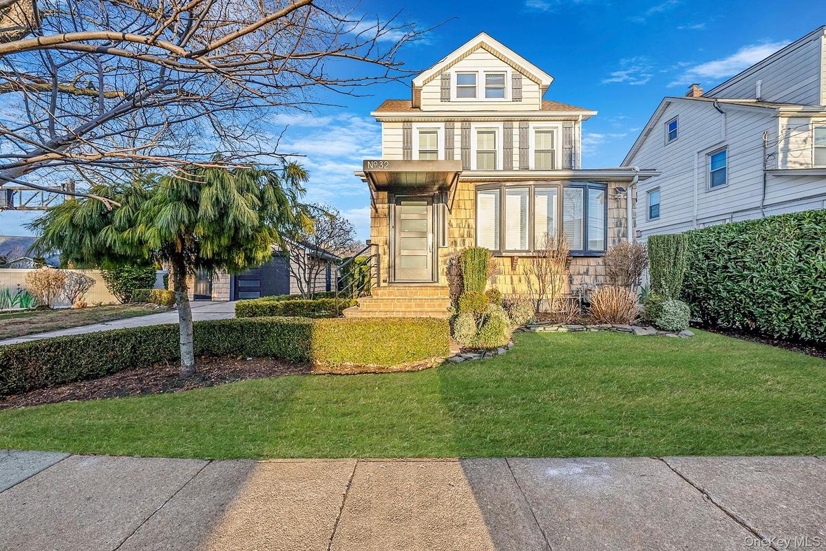 View of front of house with a front lawn and stone siding