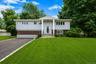Split-level residence featuring a prominent portico entrance with dual support columns