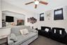 Living area with a ceiling fan, cooling unit, and carpet floors