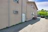 View of side of home with stucco siding and an AC wall unit