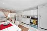 Kitchen featuring stainless steel appliances, a drop ceiling, white cabinets, light countertops, and cooling unit