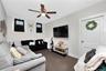 Living room featuring radiator heating unit, carpet flooring, and ceiling fan