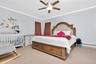 Bedroom with crown molding, light colored carpet, and ceiling fan