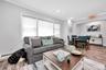 Living area featuring wood finished floors, a baseboard radiator, crown molding, and recessed lighting