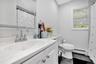 Full bath with a baseboard heating unit, vanity, and tile patterned floors