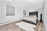 Bedroom with a baseboard heating unit, wood finished floors, recessed lighting, and crown molding