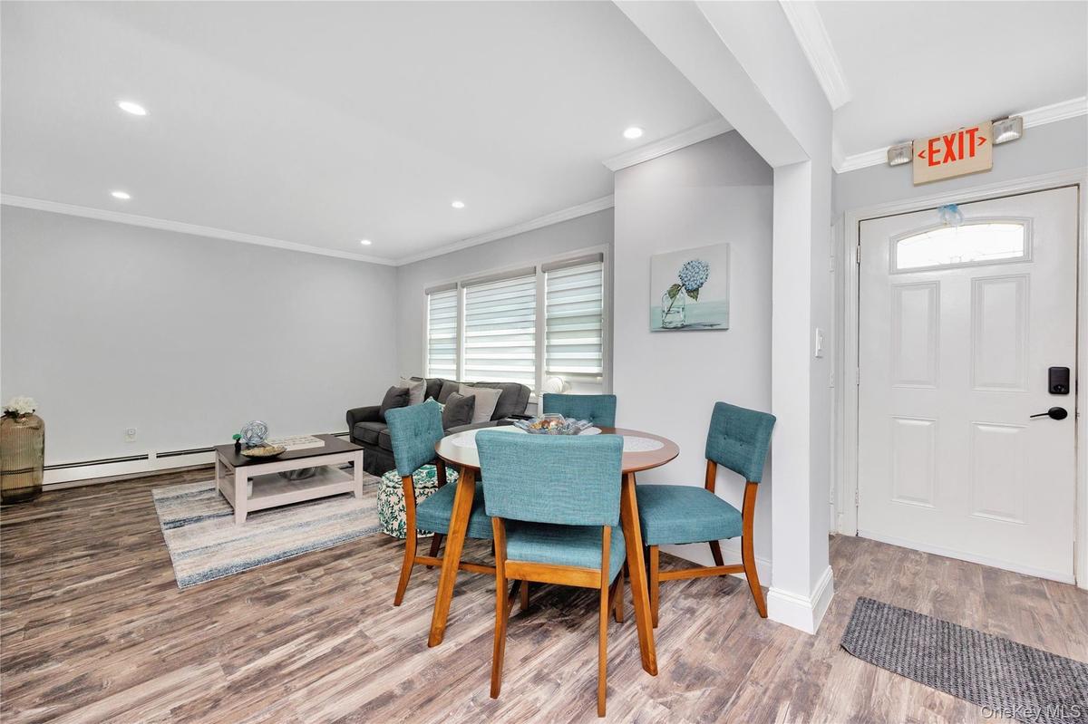 Dining room with ornamental molding, a baseboard heating unit, wood finished floors, and recessed lighting