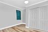 Unfurnished bedroom featuring light wood-style flooring, ornamental molding, and a closet