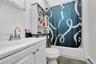 Full bath with a baseboard radiator, vanity, and shower / bath combo with shower curtain