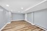 Finished basement featuring a baseboard heating unit, recessed lighting, and light wood-type flooring