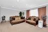 Carpeted living area with crown molding, recessed lighting, and a baseboard heating unit