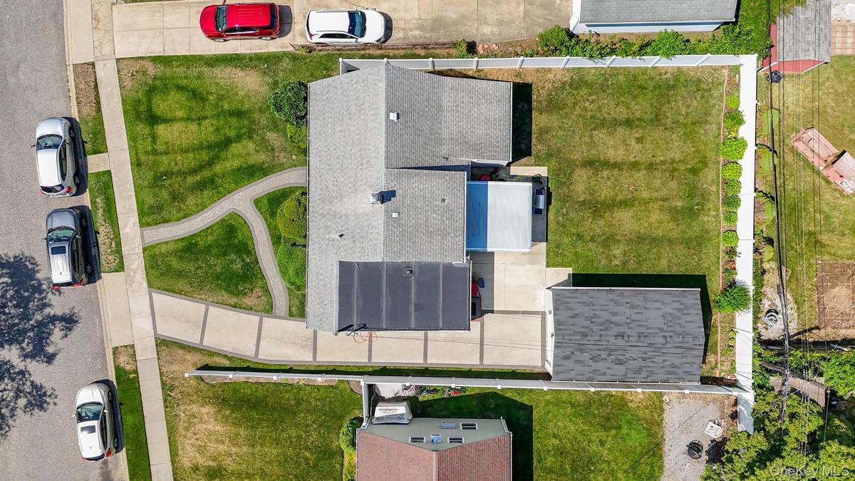 Aerial property view featuring a light gray shingle roof and a detached garage