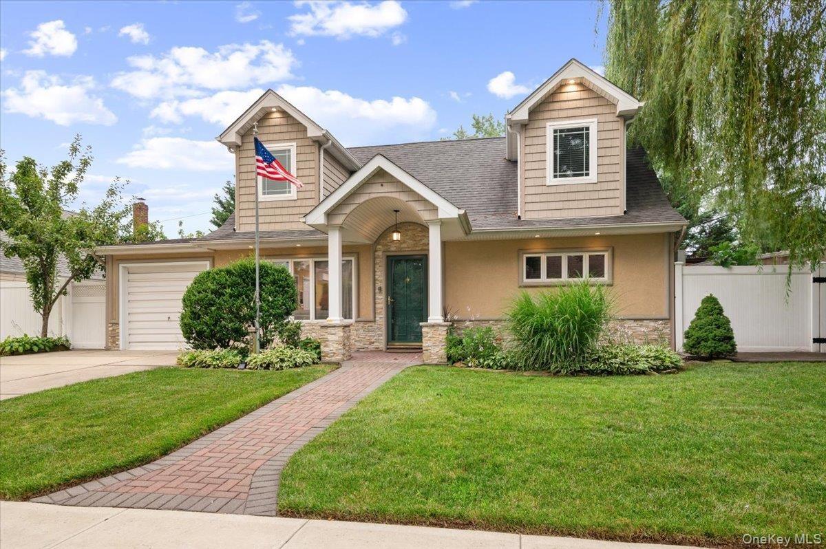 Beautifully Updated and Expanded Cape with Oversized Portico, Stone, Stucco, Vinyl Siding and newer architectural shingle roof.