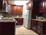 Kitchen with stainless steel appliances, glass insert cabinets, light stone counters, and decorative backsplash
