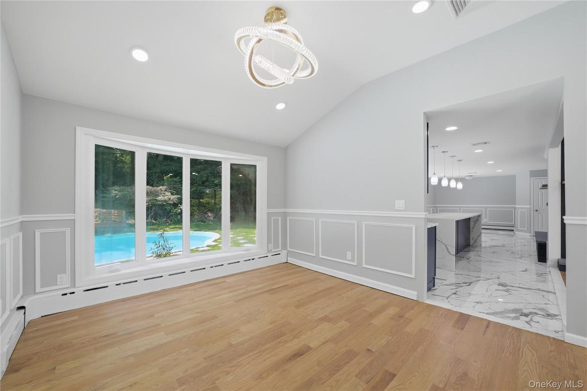 Open concept dining area featuring vaulted ceilings, recessed lighting, and wood-finish flooring