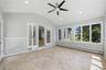 Light-filled room featuring large windows, a vaulted ceiling, recessed lighting, a ceiling fan, and tile flooring