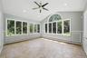 Light-filled room featuring large windows, a vaulted ceiling, recessed lighting, a ceiling fan, and tile flooring