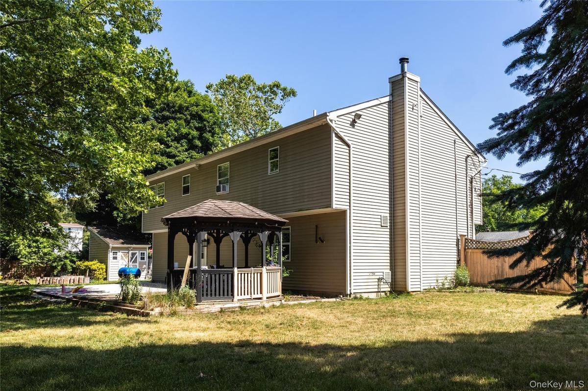 Exterior featuring light-colored siding, a prominent chimney, and a multi-level structure