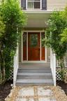 Inviting entryway featuring a rich wood-finish front door with leaded glass, flanked by coordinating sidelights