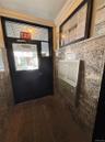 Entryway featuring multi-unit mailboxes, dark-toned flooring, and patterned wall finishes