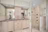 Primary bathroom with dual vanities and glass enclosed shower