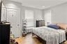 Bedroom featuring wood-finish flooring and two windows with blinds