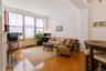 Spacious living room with oversized windows and parquet floors