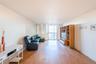 Living room with light wood finished floors, floor to ceiling windows, and a textured ceiling