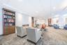 Carpeted living room featuring built in shelves, a high end fireplace, and recessed lighting