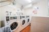 Shared laundry with tile walls and independent washer and dryer