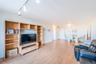 Living room with light wood finished floors and rail lighting